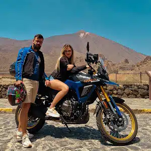 Couple next to Suzuki VStrom 800 DE and with Teide in the background in Tenerife