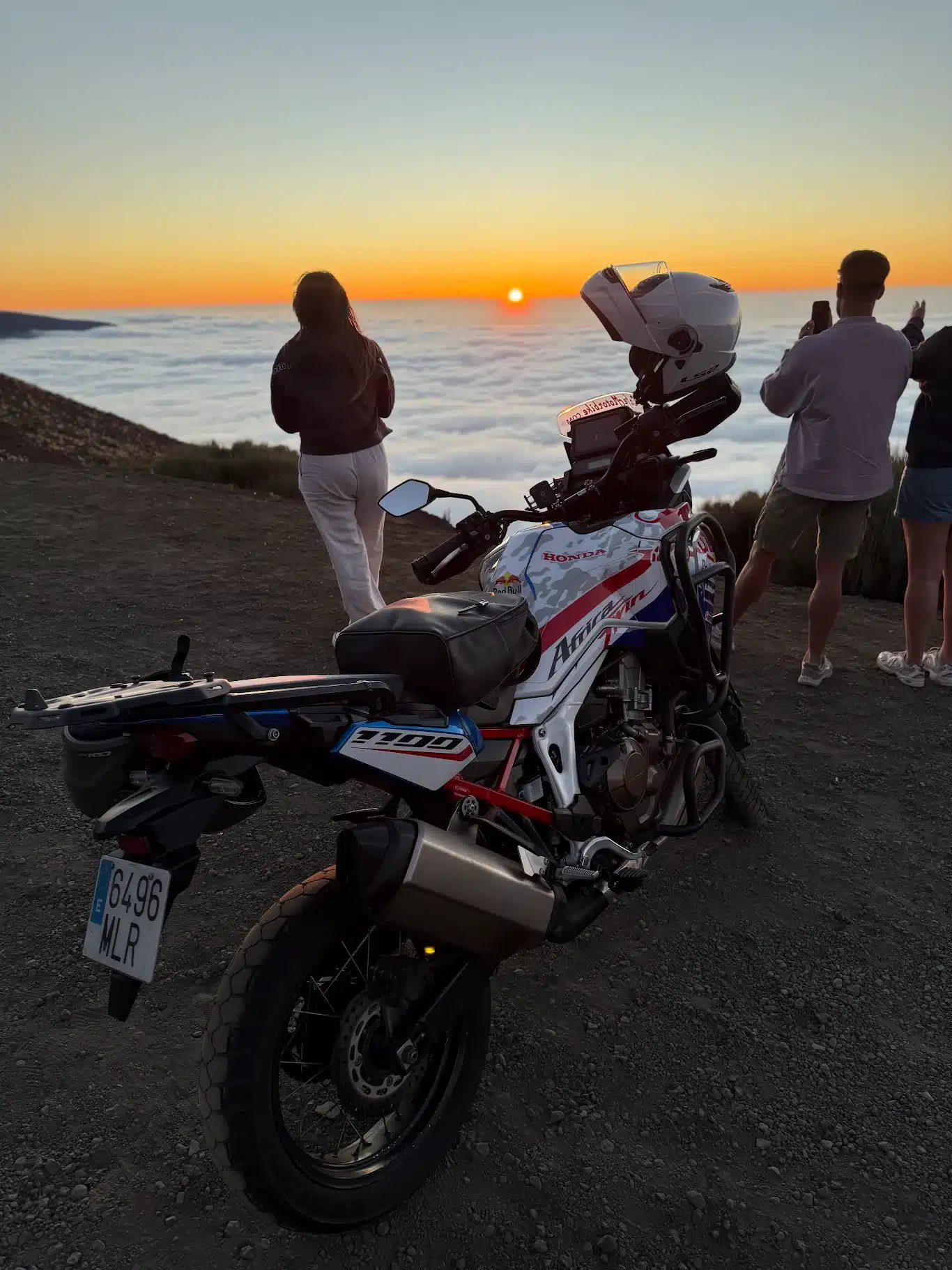 Motorcyclists admire the sunset over Teide, with a Honda Africa Twin 1100 at their side.